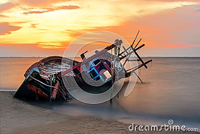 Shipwreck or wrecked boat on beach in the suset. Beautiful Landscape Stock Photo