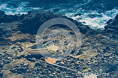 Shipwrecked vessel on a rocky shore Stock Photo