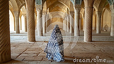 Unidentified woman walking in prayer hall of Vakil Mosque with columns, Shiraz, Iran Editorial Stock Photo