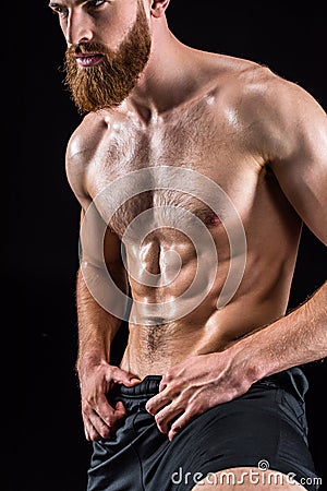 Shirtless bearded bodybuilder posing isolated on black Stock Photo