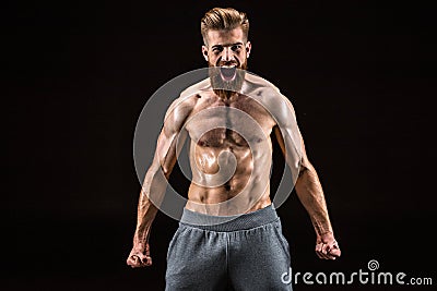 Shirtless bearded bodybuilder posing and yelling isolated on black Stock Photo