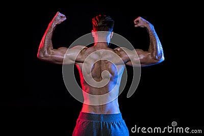 Shirtless bodybuilder gesturing isolated on black with dramatic lighting Stock Photo