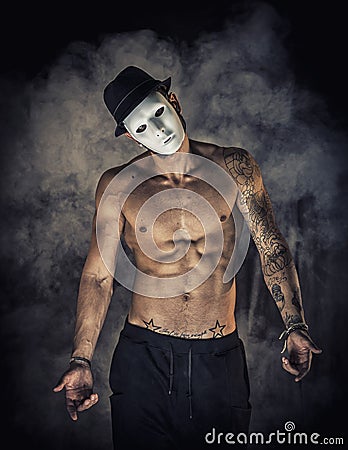 Shirtless man dancer or actor with creepy, scary mask Stock Photo