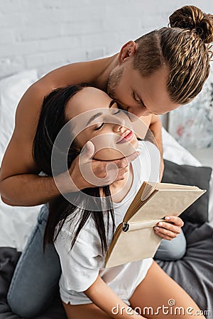 Shirtless man kissing brunette girlfriend with Stock Photo