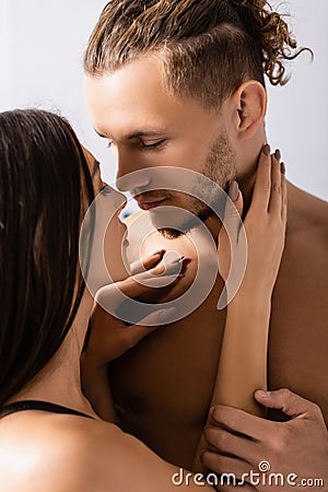 Shirtless man kissing brunette girlfriend at Stock Photo