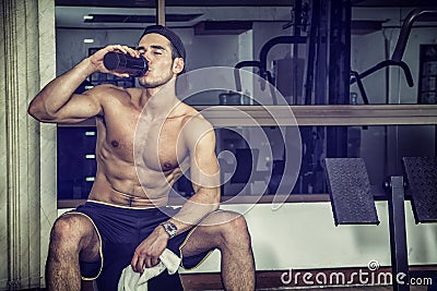 Shirtless young man drinking protein shake in gym Stock Photo