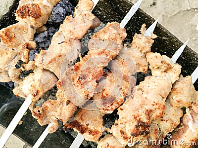 Shish kebab on metal sticks roasted on the grill Stock Photo