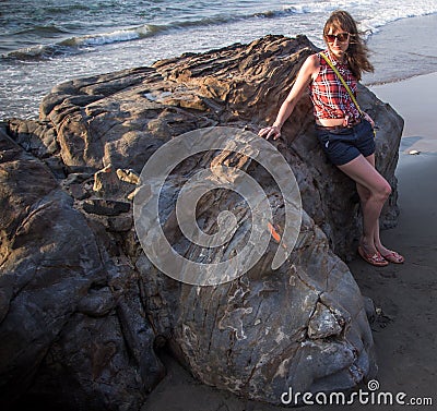 Shiva Rock Carving, North Goa, India. Young woman at Little Vagator Beach Stock Photo