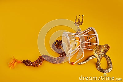 Shivaratri background with Shivas trident, Pellet Drum Damroo musical instrument ans snake . Maha Shivratri festval Stock Photo