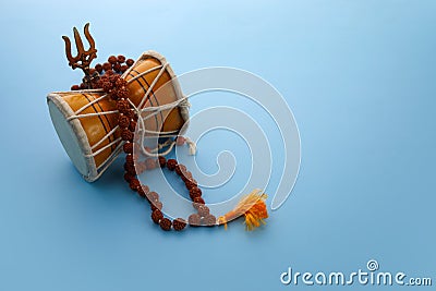 Shivaratri background with Shivas trident and Pellet Drum Damroo musical instrument . Hindu festival Maha Shivratri Stock Photo