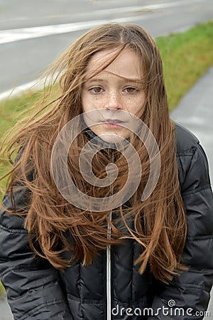 Shivering girl outside in stormy weather Stock Photo