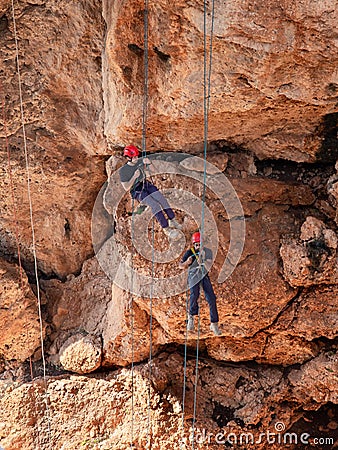 Two athletes make the descent on a rope down - climbing - snapping - the rope from the mountain to Keshet, Cave in northern Israel Editorial Stock Photo