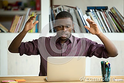 Shocked african american office worker looking at laptop screen. Stock Photo