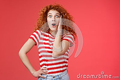 Shocked amused emotive redhead ginger girl curly haircut popping eyes stare camera fascinated impressed open mouth Stock Photo