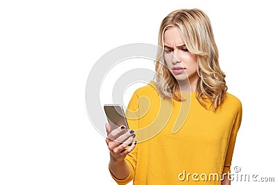 Shocked angry young woman looking at her mobile phone in disbelief. Woman staring at shocking text message on her phone. Stock Photo