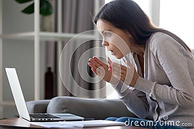 Shocked attractive woman looking with amazement at laptop screen Stock Photo