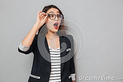 Shocked business woman in eyeglasses looking away with open mouth Stock Photo