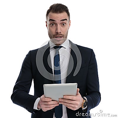 Shocked businessman holding tablet and gasping Stock Photo