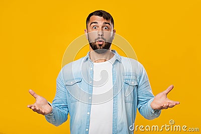 Shocked confused mature caucasian male with beard spreads his arms to sides, dont now what to choose Stock Photo