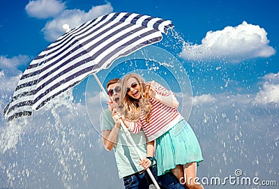 Shocked couple under the umbrella because of the stormy weather Stock Photo