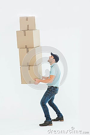 Shocked delivery man carrying stack of boxes Stock Photo