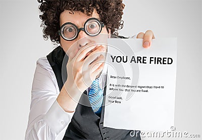 Shocked employee is showing letter with You are fired message Stock Photo