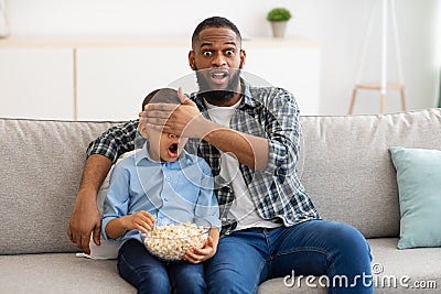 Shocked Father Covering Son& x27;s Eyes Watching Questionable TV Content Indoor Stock Photo