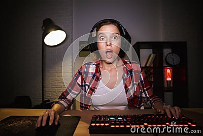 Shocked girl gamer sitting at the table Stock Photo