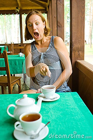 Shocked girl sees something in cup of tea Stock Photo