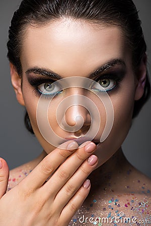 shocked glamorous girl posing with makeup and glitter on body Stock Photo