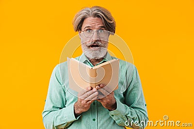 Shocked grey-haired bearded man reading book Stock Photo