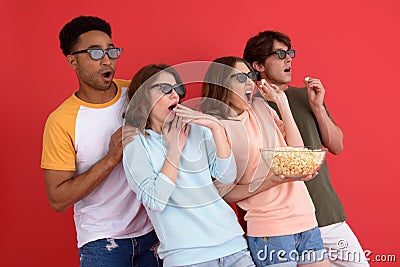 Shocked group of friends watching film eating popcorn. Stock Photo
