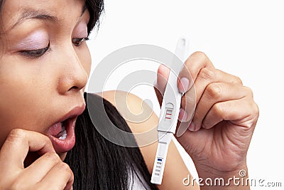 Shocked looking at pregnancy test result Stock Photo