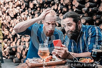 Two bearded men feeling shocked after checking score of the game Stock Photo