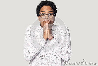 Shocked millennial ethnic woman covering mouth with hands. Stock Photo