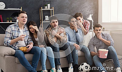 Shocked multiethnic friends watching movie at home Stock Photo