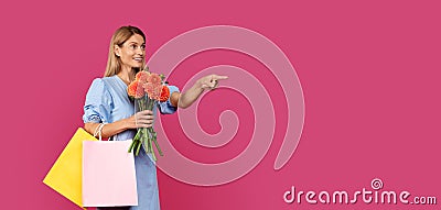 Shocked smiling adult caucasian lady blonde in dress with many packages with purchases and bouquet Stock Photo