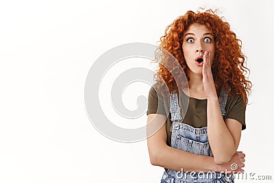 Shocked and speechless cute modern redhead curly-haired girl, gasping amazed, drop jaw fascinated and impressed, stare Stock Photo