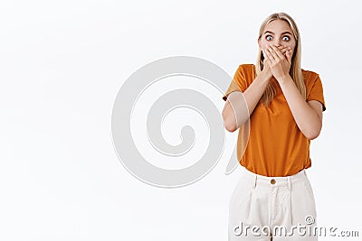 Shocked stunned blond girl freak-out from surprised impressive news, gasping cover opened mouth not to shout as stare Stock Photo