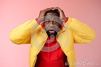 Shocked stupefied young african-american bearded man grab head drop jaw gasping confused frustrated looking upset Stock Photo