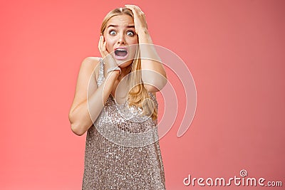 Shocked terrified blond woman horrified see crime screaming pop eyes shouting hold hands head afraid trembling fear Stock Photo