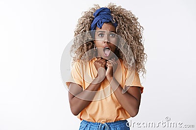 Shocked timid and innocent cute, hipster african-american female with blond afro hair, orange t-shirt gasping shocked Stock Photo