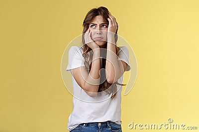 Shocked timid insecure young panicking woman wanna cry standing anxious frightened grab head both hands freak out look Stock Photo