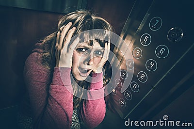 Shocked woman with claustrophobia in the moving elevator Stock Photo