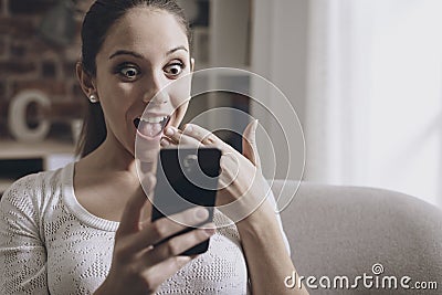 Shocked woman connecting with her smartphone Stock Photo