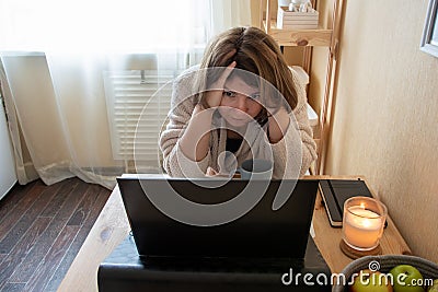 Shocked woman grabbed her head with her hands while working at a computer at home Stock Photo