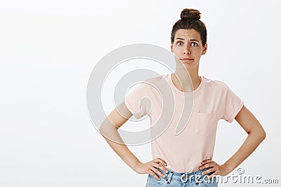 Shocked woman suggesting friend go to doctor. Intense bothered and displeased female with messy hair bun holding hand on Stock Photo