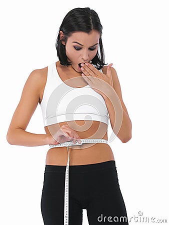 Shocked woman, tape measure and weight loss of waist for slim body or diet on a white studio background. Surprised Stock Photo