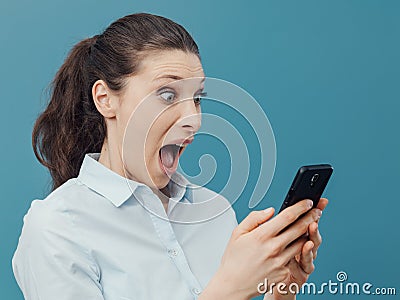 Shocked woman using a smartphone and connecting Stock Photo