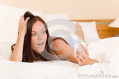 Shocked woman wake-up bed watch alarm clock Stock Photo